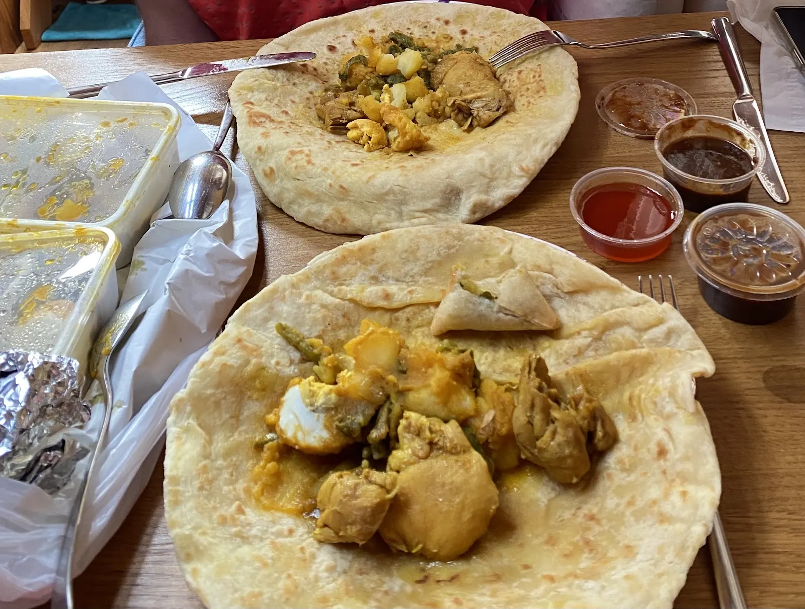 Roti met kip, aardappel, ei en kousenband in kerriesaus, met een samosa en sausjes